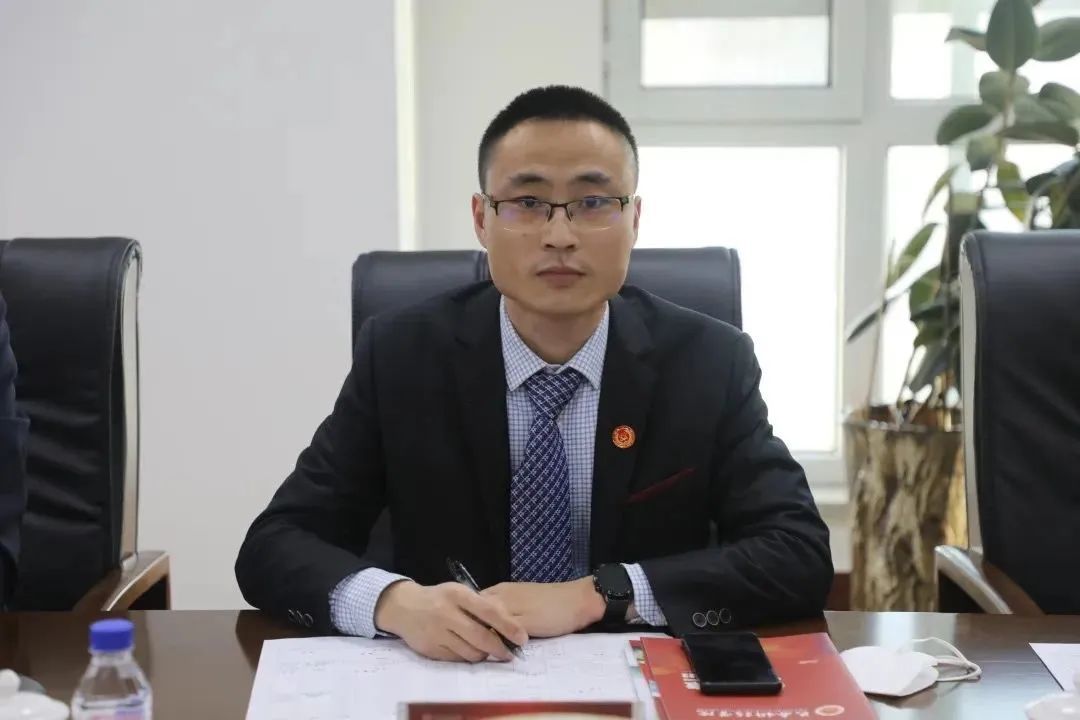 桌子前坐着穿西装的人中度可信度描述已自动生成 桌子前坐着穿西装的人中度可信度描述已自动生成